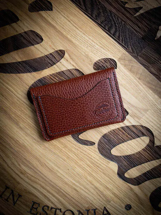 Handmade embossed brown vegetable tanned leather card wallet with a flap closure and an outer pocket