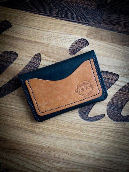 Handmade black and almond brown vegetable tanned leather card wallet with a flap closure and outer pocket