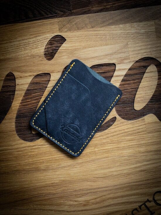 Handmade minimalist vegetable tanned leather cardholder in blue color with yellow stitching